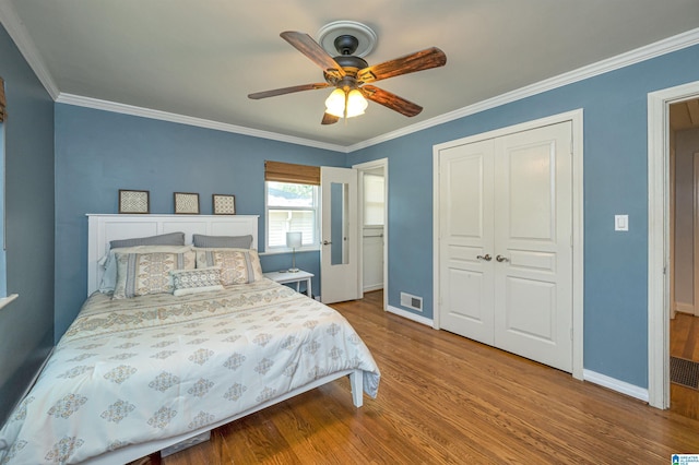 bedroom with visible vents, a closet, baseboards, and wood finished floors