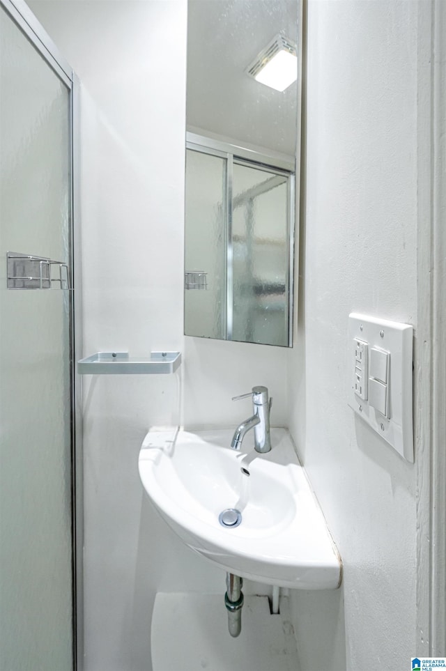 full bathroom featuring a sink and a stall shower