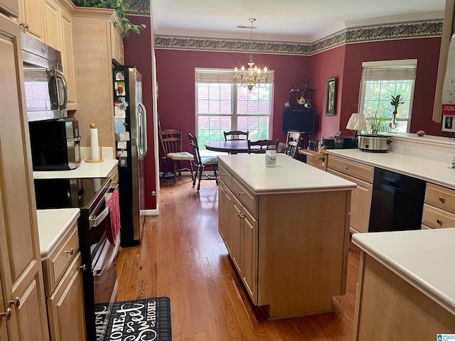 kitchen featuring pendant lighting, stainless steel appliances, a center island, light hardwood / wood-style floors, and a chandelier