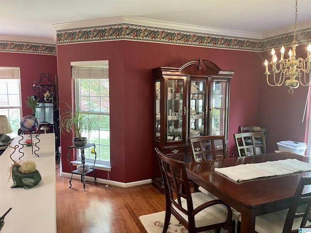 dining space featuring hardwood / wood-style flooring, crown molding, and a notable chandelier