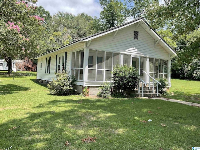 rear view of property with a sunroom and a yard