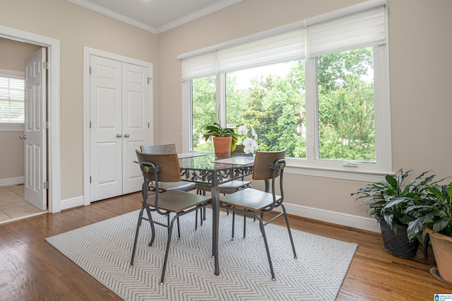 dining space with ornamental molding, hardwood / wood-style floors, and plenty of natural light