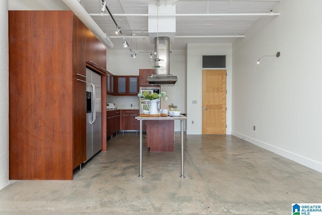 kitchen featuring concrete flooring, a kitchen island, appliances with stainless steel finishes, tasteful backsplash, and a kitchen bar