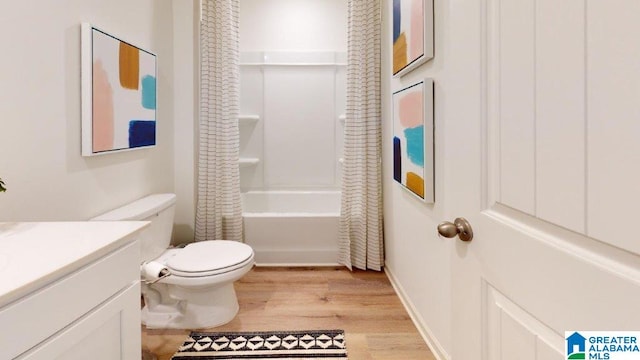 full bathroom featuring toilet, hardwood / wood-style floors, vanity, and shower / tub combo with curtain