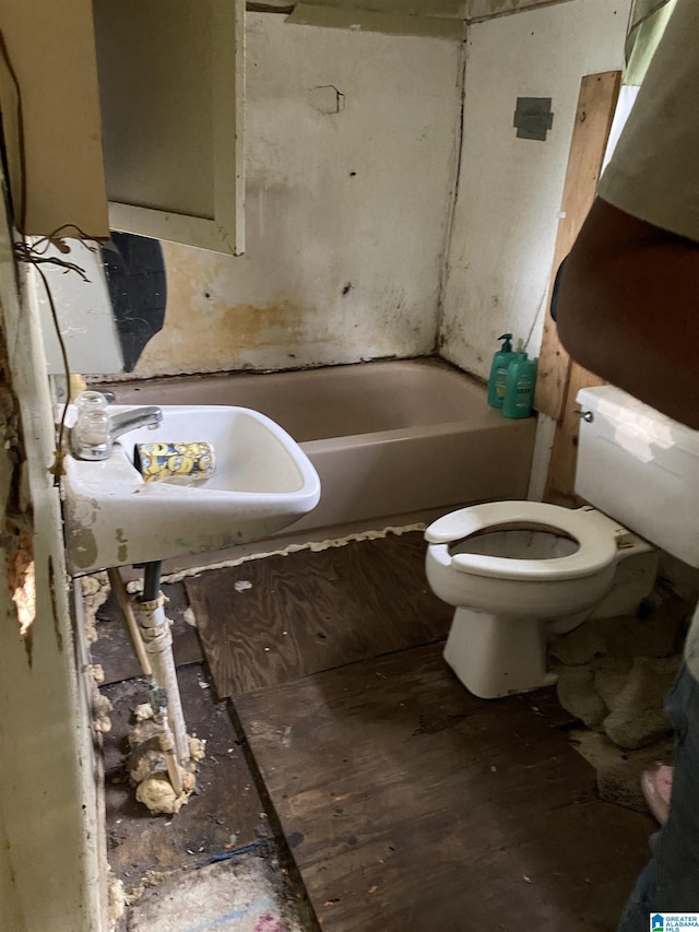 bathroom featuring sink, a bathtub, and toilet