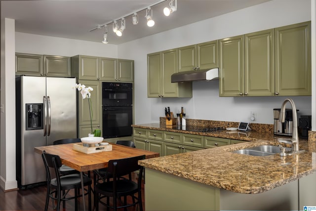 kitchen with a breakfast bar area, stone counters, black appliances, green cabinets, and dark wood-type flooring