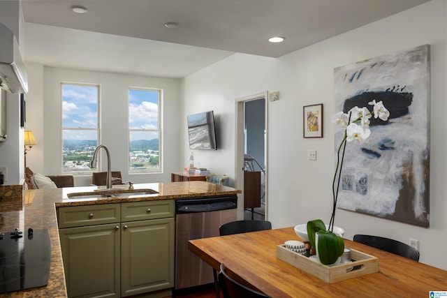 kitchen featuring stainless steel dishwasher, green cabinets, stovetop, wall chimney exhaust hood, and sink