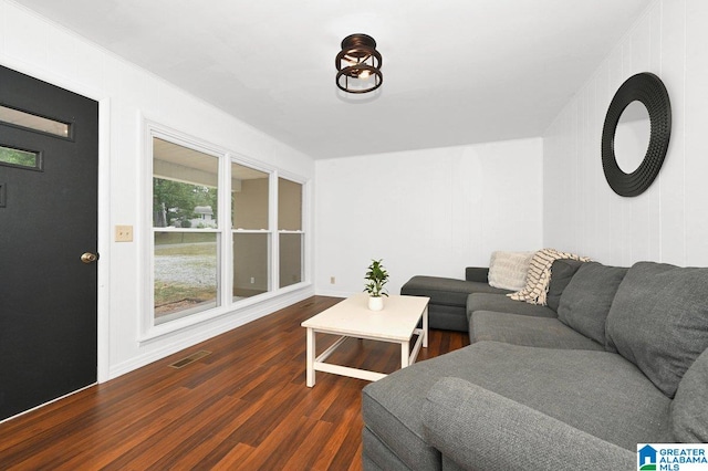living room featuring baseboards, visible vents, and wood finished floors