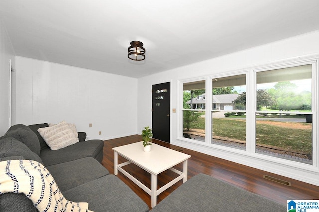 living room featuring visible vents, wood finished floors, and baseboards