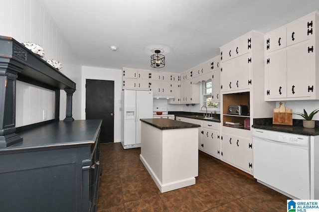 kitchen featuring white cabinetry, white appliances, dark countertops, and a center island