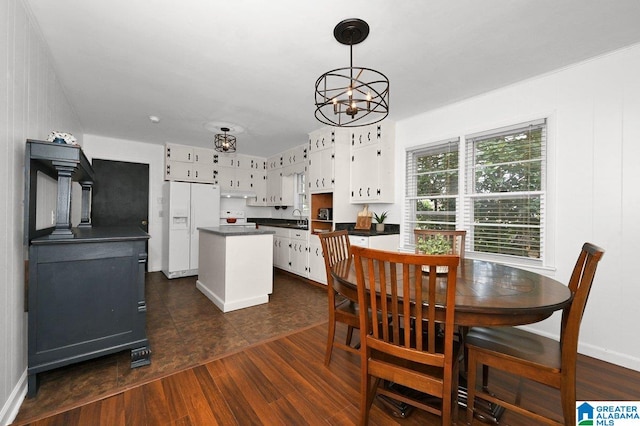 dining area featuring an inviting chandelier, dark wood-style flooring, and baseboards