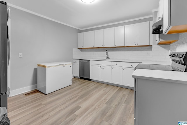 408 N Main St, Graysville, AL 35073 - kitchen featuring stainless steel appliances, light wood-style floors, a sink, decorative backsplash, and ornamental molding