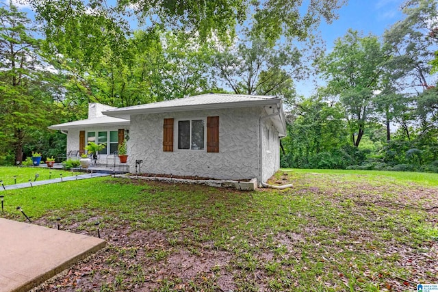 408 N Main St, Graysville, AL 35073 - view of front of property with stucco siding, a front lawn, a chimney, and metal roof