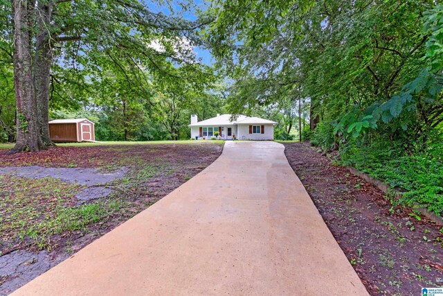 408 N Main St, Graysville, AL 35073 - single story home with a shed, concrete driveway, an outbuilding, and a chimney