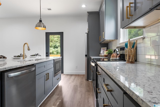 kitchen featuring sink, hanging light fixtures, gray cabinetry, and appliances with stainless steel finishes