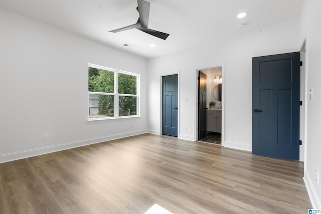 unfurnished bedroom featuring ceiling fan, light hardwood / wood-style floors, and connected bathroom