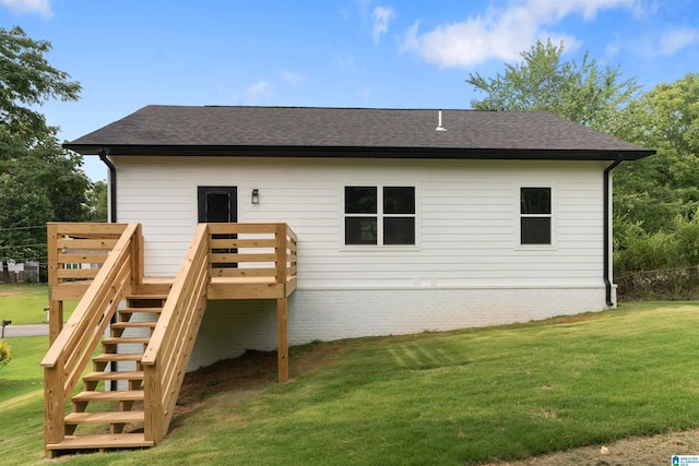 rear view of house with a lawn and a wooden deck