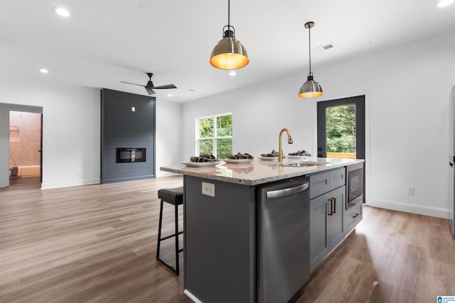 kitchen with appliances with stainless steel finishes, an island with sink, ceiling fan, pendant lighting, and sink