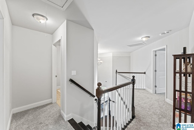 hallway with light colored carpet and an inviting chandelier