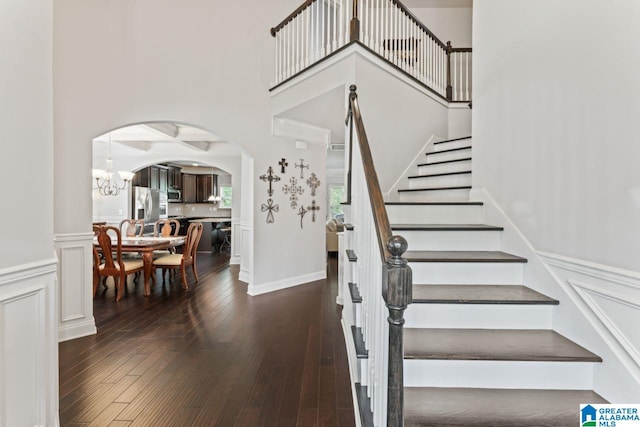 staircase with a chandelier and hardwood / wood-style floors