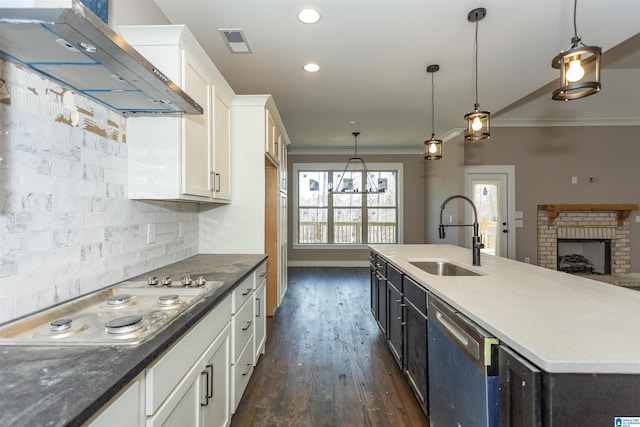 kitchen with electric cooktop, wall chimney exhaust hood, ornamental molding, a sink, and stainless steel dishwasher