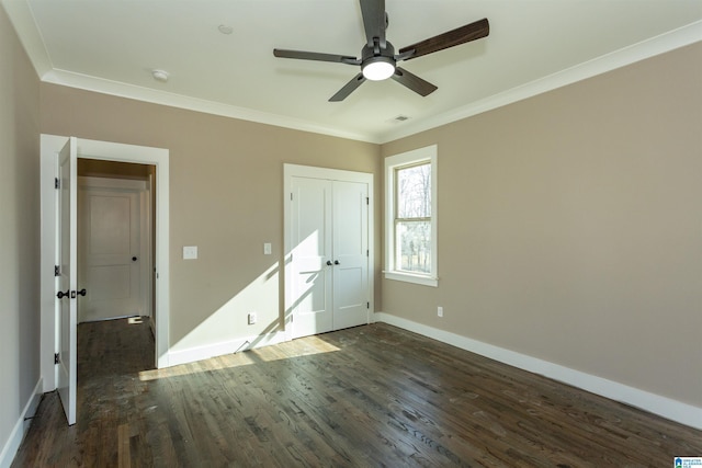 unfurnished bedroom featuring baseboards, visible vents, dark wood-style flooring, and crown molding