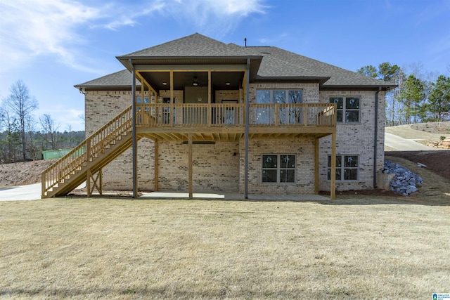 rear view of property with a patio, brick siding, a shingled roof, a yard, and stairway