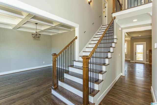 staircase featuring coffered ceiling, wood finished floors, and baseboards