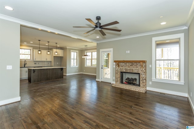 unfurnished living room featuring baseboards, ceiling fan, ornamental molding, and dark wood-style flooring