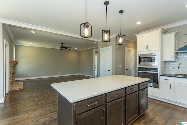 kitchen with stainless steel appliances, white cabinets, ornamental molding, decorative backsplash, and dark wood finished floors