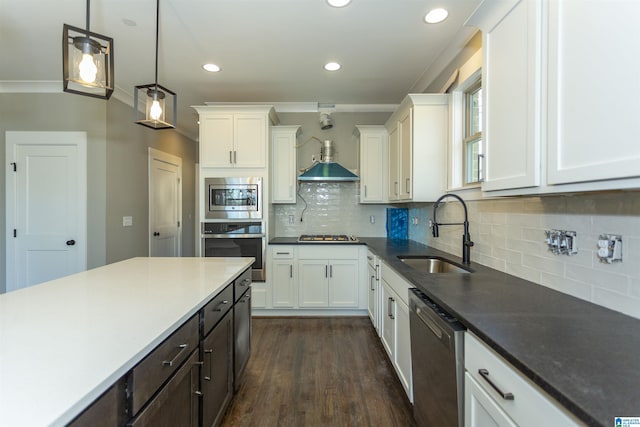 kitchen with stainless steel appliances, white cabinets, a sink, and wall chimney exhaust hood