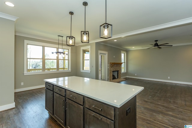 kitchen with a fireplace, baseboards, dark wood-type flooring, and ornamental molding