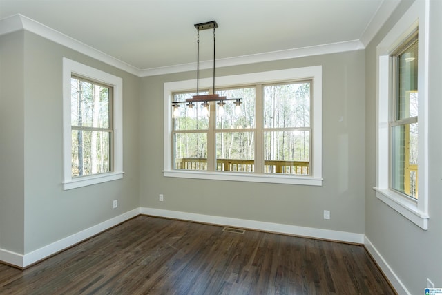 unfurnished dining area featuring dark wood-style flooring, visible vents, crown molding, and baseboards