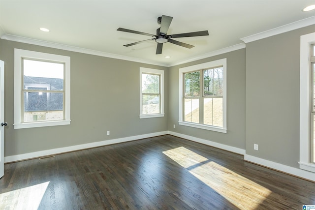 spare room with crown molding, wood finished floors, visible vents, and baseboards