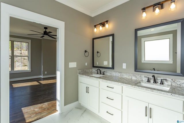 full bath featuring marble finish floor, ornamental molding, a sink, and baseboards