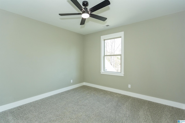 carpeted empty room featuring visible vents, baseboards, and a ceiling fan