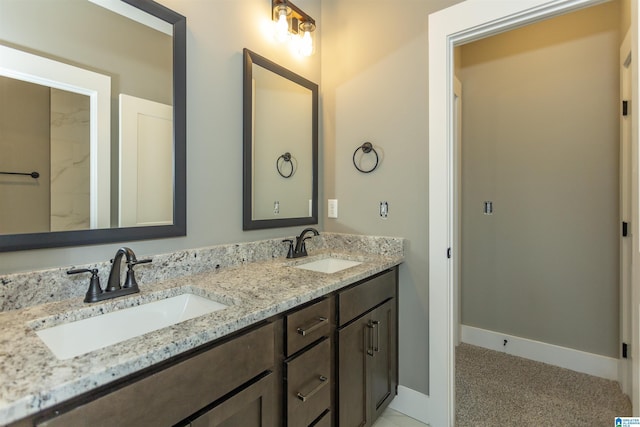 full bathroom featuring double vanity, a sink, and baseboards