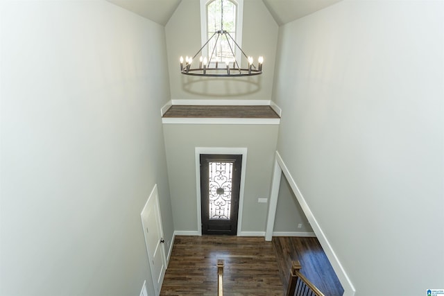 entrance foyer featuring baseboards, high vaulted ceiling, wood finished floors, and an inviting chandelier