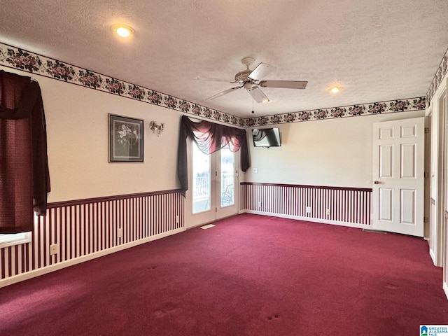 carpeted spare room with ceiling fan and a textured ceiling