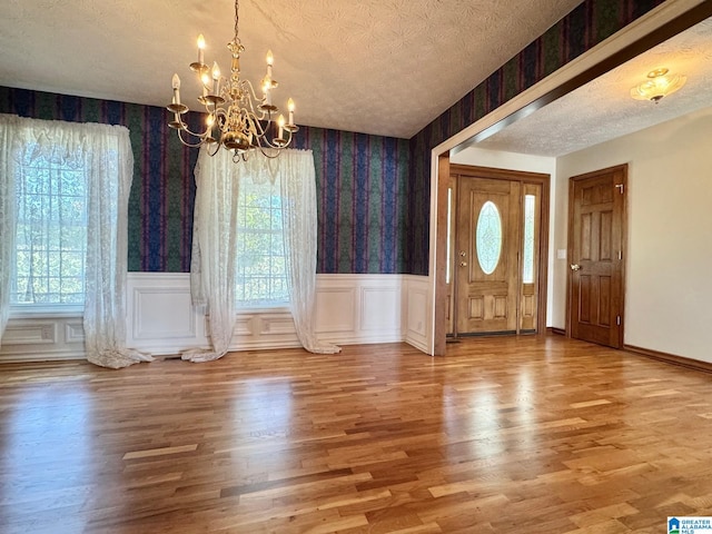 foyer with a chandelier, a textured ceiling, and wood-type flooring