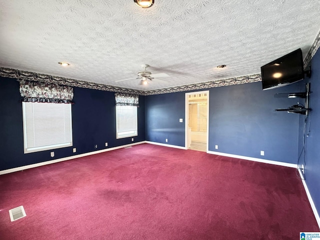 carpeted spare room with ceiling fan and a textured ceiling