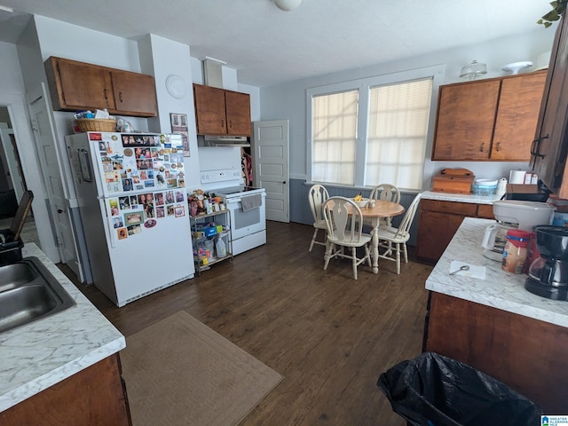 kitchen featuring white appliances, dark hardwood / wood-style floors, and sink