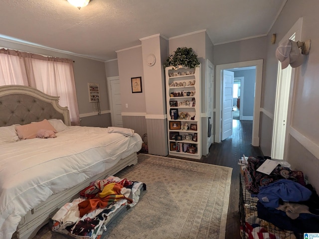 bedroom with ornamental molding, a textured ceiling, and dark wood-type flooring