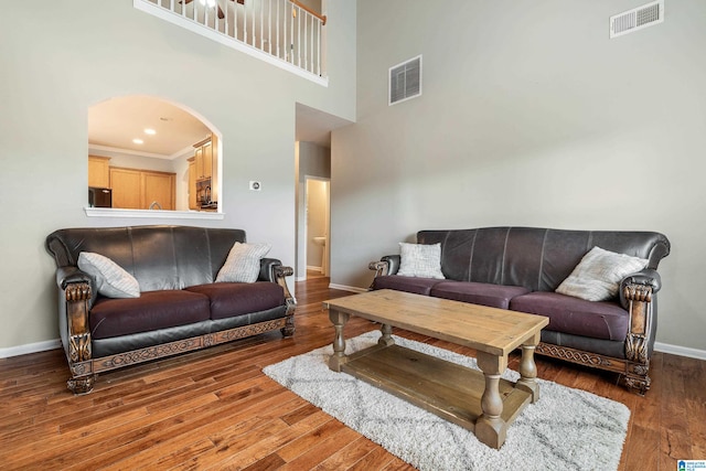 living room featuring hardwood / wood-style flooring and a high ceiling