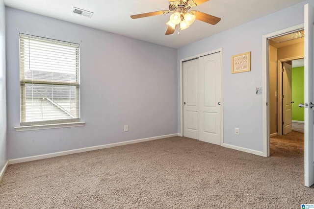 unfurnished bedroom with carpet, a closet, and ceiling fan