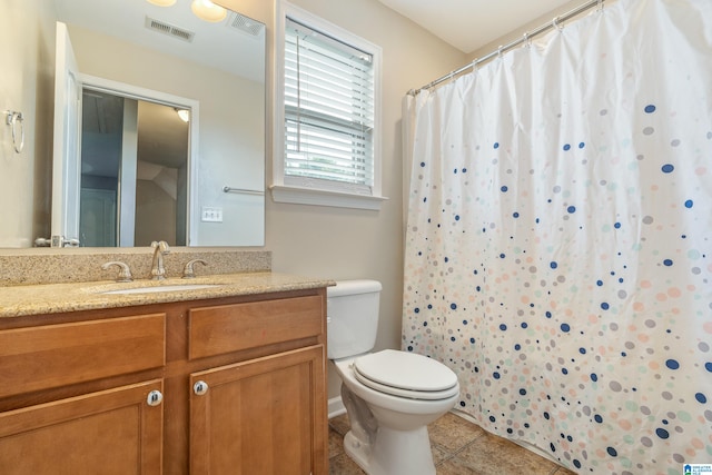 bathroom featuring vanity, toilet, and tile patterned flooring