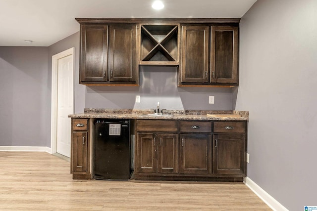 interior space with light hardwood / wood-style flooring, sink, dark brown cabinetry, light stone countertops, and dishwasher