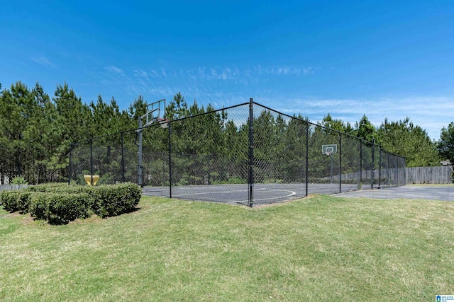 view of sport court featuring a lawn