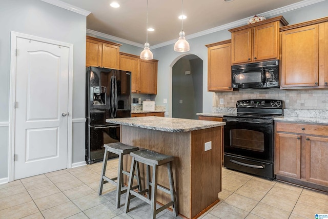 kitchen with light tile patterned flooring, crown molding, backsplash, a center island, and black appliances