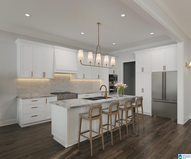 kitchen with high end appliances, backsplash, a kitchen island with sink, white cabinetry, and dark wood-type flooring